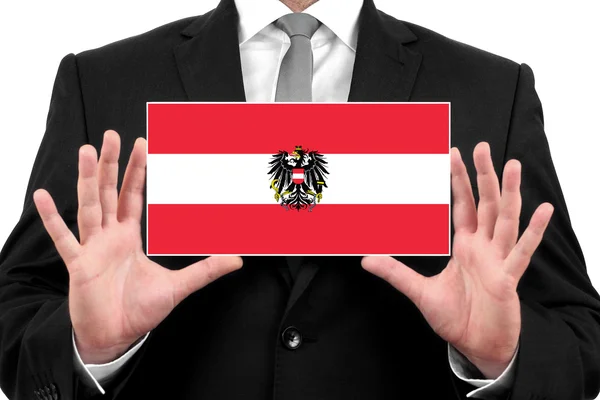 Empresário segurando um cartão de visita com a bandeira da Áustria — Fotografia de Stock