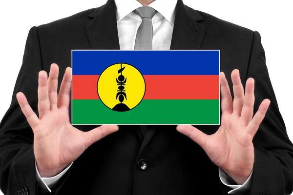 Businessman holding a business card with New Caledonia Flag — Stock Photo, Image