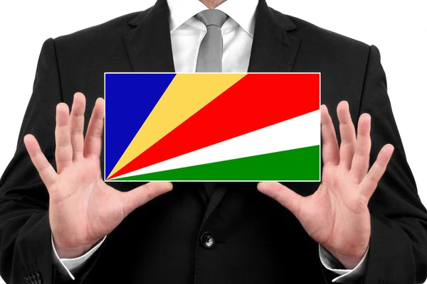 Бизнесмен, держащий визитку с Сейшельским флагом — стоковое фото