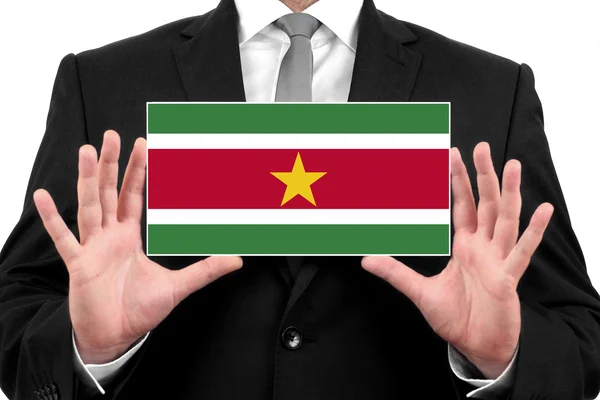 Empresário segurando um cartão de visita com Bandeira do Suriname — Fotografia de Stock