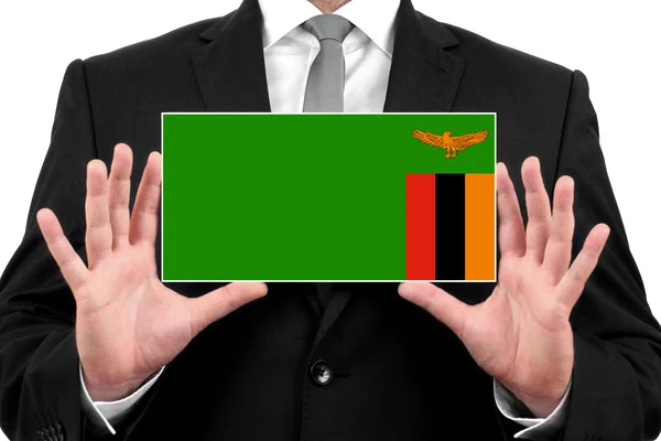 Businessman holding a business card with Zambia Flag — Stock Photo, Image