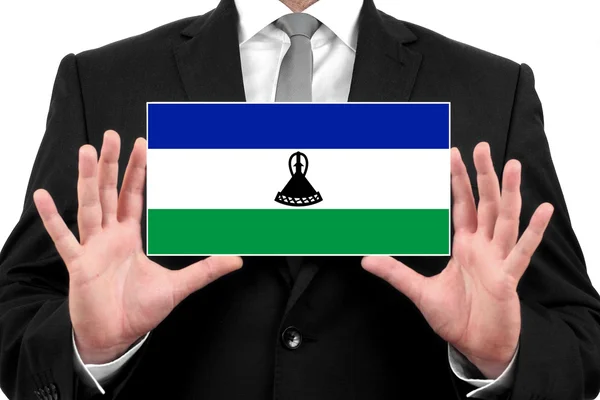 Бизнесмен, держащий визитку с флагом Лесото — стоковое фото