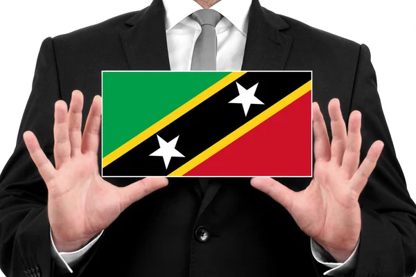 Affärsman som innehar ett visitkort med saint kitts och nevis flagga — Stockfoto