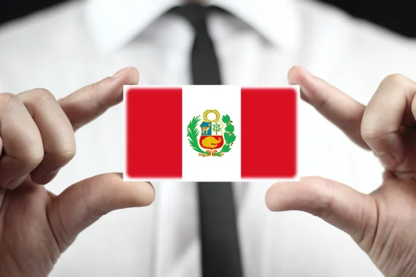 Empresário segurando cartão de visita com bandeira do Peru — Fotografia de Stock