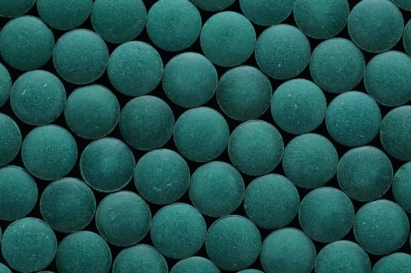 Spirulina tablets close up top view. Flat lay Healthy food supplement. Super food ingredient. top view