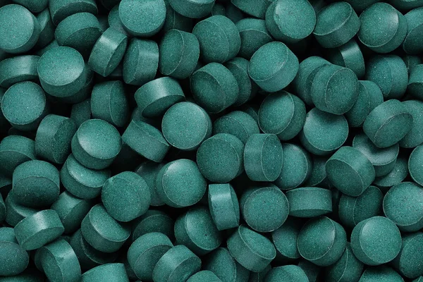 Spirulina tablets close up top view. Flat lay Healthy food supplement. Super food ingredient. top view