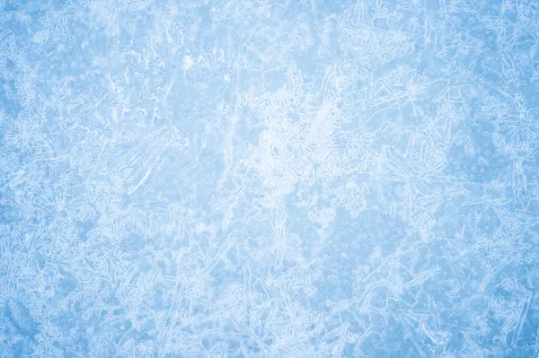 O gelo azul é texturizado com geada branca e um padrão encaracolado brilhante de veias de gelo com iluminação natural. Contexto — Fotografia de Stock