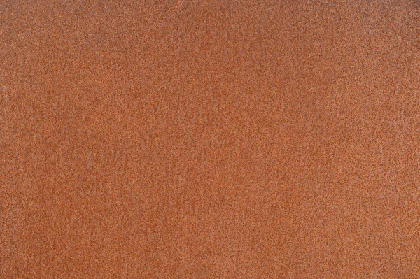 Rusty kovový plech s jednotnou oranžovou korozí v jednotném osvětlení. Pozadí — Stock fotografie