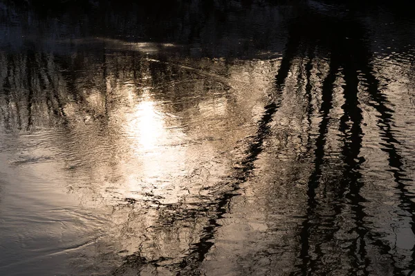 Przepływ rzeki w odbiciu porannego światła słońca w spokojnych falach. Kontekst — Zdjęcie stockowe