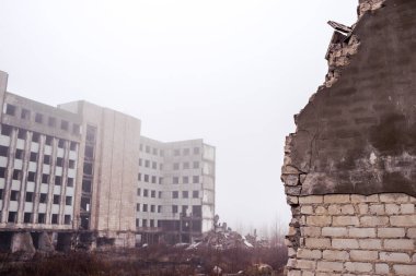Bir binanın harabelerine yakın plan bir tuğla duvar ve sisin içinde gri bir gökyüzü. Arkaplan.