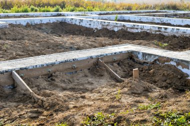 İnşaatın başında bir kır evinin dökülen beton çözeltisinin temeli. Arkaplan.