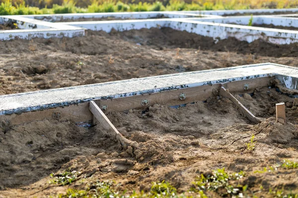 The foundation of a poured concrete solution of a country house in close-up at the beginning of construction. Background.