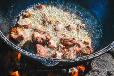 Lanet bir kabuğu elde etmek için sebze yağının üzerinde küçük porsiyonlarda et kızartıyorlar..