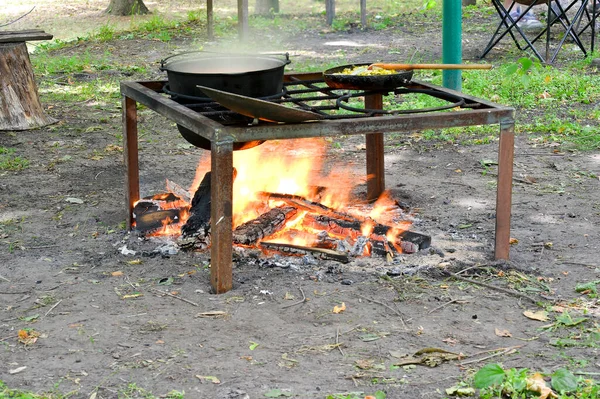 Kazan on an open fire on a metal grill for cooking pilaf on a tourist base.