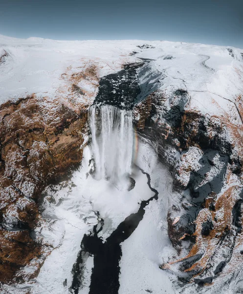 Aerial drone view of Skogafoss waterfall in winter with blue sky and colourful orange grass. — Stock Photo, Image