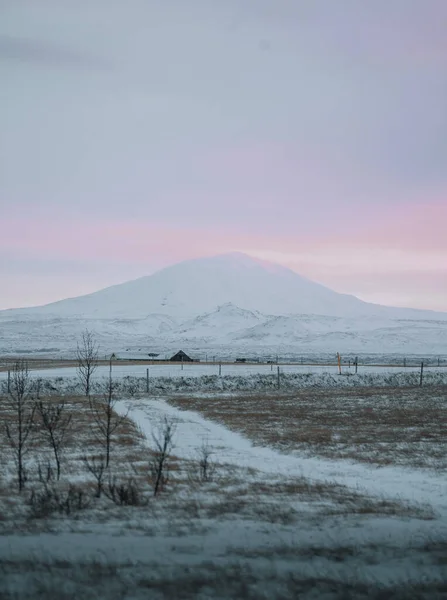 Tájkép kilátás Hekla vulkán Dél-iceland téli naplementekor hó és bolyhos rózsaszín felhők. — Stock Fotó