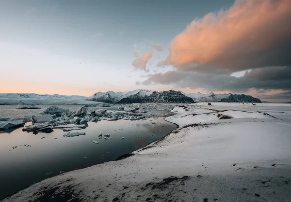 Flygdrönare panorama över berömda sjön Joekulsarlon glacial lagun och diamant stranden med sina isberg och isflak på Island under solnedgången skymning på vintern. — Stockfoto