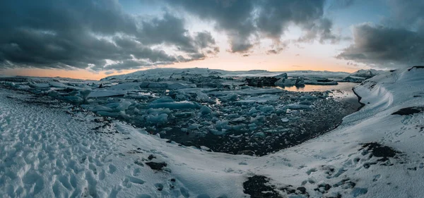 Aerial drone panorama of famous lake Joekulsarlon glacial lagoon and diamond beach with its icebergs and ice floes in Iceland during sunset twilight in winter. — Stock Photo, Image