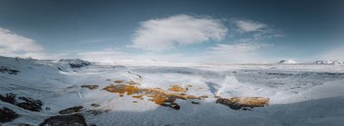 Yerden gelen sıcak buharlı hava aracı panoraması. Hver, Myvatn 'da jeotermal alan. Kar ve turuncu zemin ile kaplı arazi.
