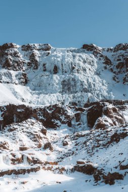 Dynjandi Foss şelalesinin ön planda buz kanyonu olan hava aracı görüntüsü. Mavi gökyüzü. Batı İzlanda 'da Batı Fiyortları