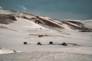 Icelandic landscape with geothermal power plant station kravla with igloo huts and pipes in the valley. Myvatn lake surroundings, Iceland