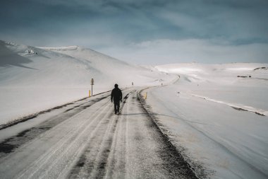 Man walking in high fresh snow leaving footsteps. Perfect winter day with blue sky and sun. Winter sports and hiking concept. Photo taken in Iceland near Akureyri and Myvatn.