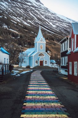 Rainbow stripes on pavement leading up to the Seydisfjordur Church in Iceland