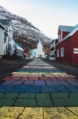Rainbow stripes on pavement leading up to the Seydisfjordur Church in Iceland