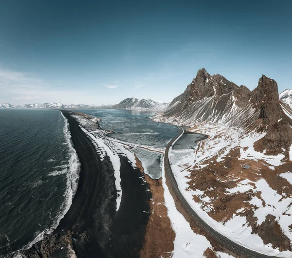 Flygfoto Drone panorama utsikt över ett snötäckt Eystrahorn berg på Island på Hvalnes halvön med svart sand strand. — Stockfoto