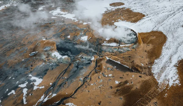 Aerial Drone panorama with hot steam coming from the ground. Hverir is geothermal area in Myvatn. Landscape covered with snow and orange ground. — Stock Photo, Image