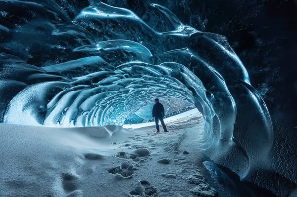 Entrada a la cueva de hielo de cristal azul con escalador turístico y un río subterráneo debajo del glaciar ubicado en las Tierras Altas en Islandia —  Fotos de Stock