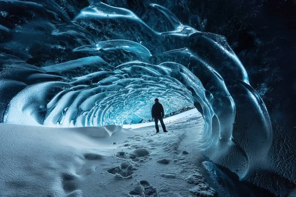 Entrada a la cueva de hielo de cristal azul con escalador turístico y un río subterráneo debajo del glaciar ubicado en las Tierras Altas en Islandia —  Fotos de Stock