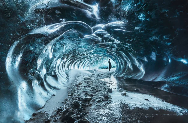 Blue crystal ice cave entrance with tourist climber and an underground river beneath the glacier located in the Highlands in Iceland — Stock Photo, Image