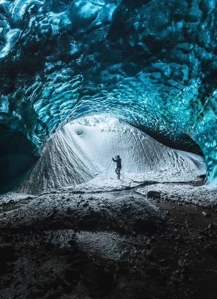 Entrada de caverna de gelo de cristal azul com escalador turístico e um rio subterrâneo sob a geleira localizada nas Terras Altas, na Islândia — Fotografia de Stock