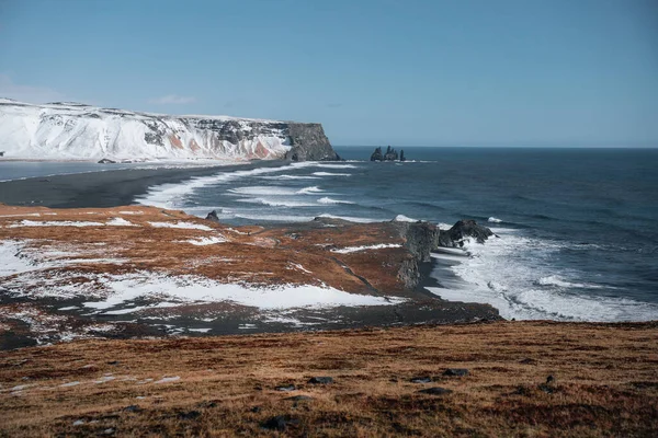 Dramatické zimní krajina islandské Black Sand Beach Reynisfjary poblíž města Vik. Bouřlivé moře pobřeží sopečného černou pláž v mlze počasí — Stock fotografie