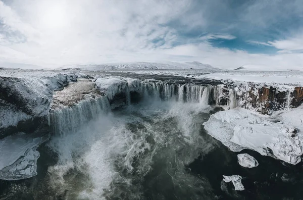 Godafoss Şelalesi 'nin insansız hava aracı görüntüsü, İzlanda, yüksek bir açıdan çekilmiş. Güçlü çağlayanın, nehrin ve karın havadan görünüşü kayaları kaplıyordu. Sonbahar sonu, kış başlangıcı sahnesi. — Stok fotoğraf