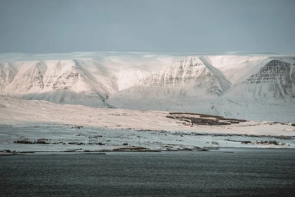 冬のアイスランドのアクレリ市のパノラマビューとフィヨルドと山の雪. — ストック写真