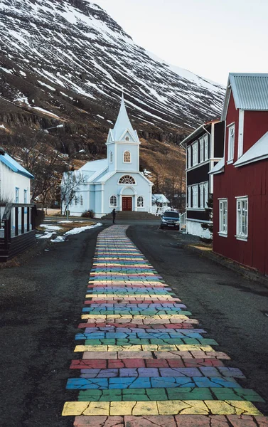 Rayures arc-en-ciel sur la chaussée menant à l'église Seydisfjordur en Islande — Photo