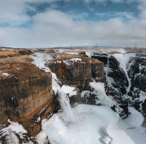 Aerial drone view of Haifoss waterfall in Iceland during Winter in the Highlands. Blue sky and clouds in snow. — стоковое фото
