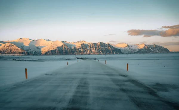 Route d'hiver dans la tempête de neige. De la poudrerie sur la route. Conditions de conduite difficiles en hiver en Islande. Journée ensoleillée mais venteuse, typiquement islandaise. Conduite sécuritaire islandaise . — Photo
