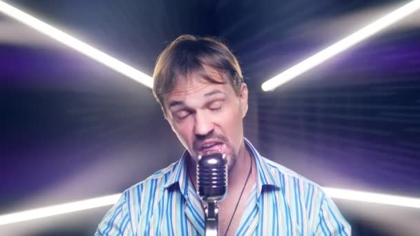 Retrato de un hombre con bigote y barba cantando en un micrófono en el escenario — Vídeos de Stock