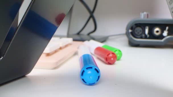 Detailed extreme close-up, multi-colored markers, computer keyboard and audio card on a desk — Vídeo de Stock