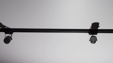 Ceiling black spotlights on a rail system on a white ceiling background