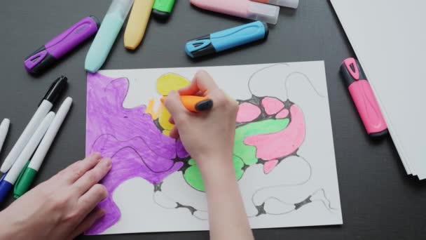 Neurographics close-up top view. a female hand paints a drawing with black neurographic lines with colored markers — стоковое видео