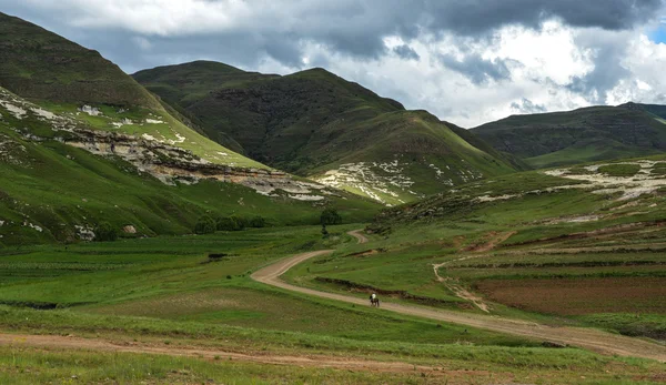 Monterade sotho man rider bort in i lesotho landskap — Stockfoto