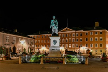 Salzburg, Avusturya; 10 Temmuz 2021 - Mozartplatz 'ın merkezinde Ludwig Schwanthaler' in geceleri yaptığı Mozart heykeli yer almaktadır. Mozartplatz, Salzburg 'un Eski Şehir' inin merkezinde yer almaktadır.