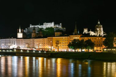 Salzburg şehri akşam manzarası. Katedral, Altstadt Eski Kasabası, Evangelische Pfarrgemeinde Christuskirche Hohensalzburg Şatosu geceleri aydınlatıldı. Salzach Nehri kıyısı geçidi Salzburg, Avusturya.