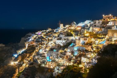 Klasik Oia ve Santorini geceleri Yunanistan 'daki binalarla gökyüzüne yükseliyor.