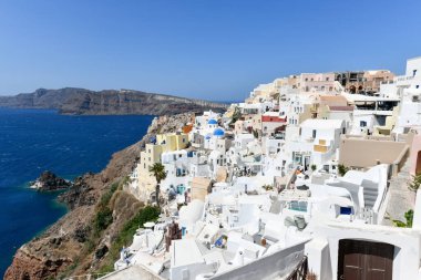 Yunanistan 'ın Santorini adasındaki Oia köyünün büyüleyici manzarası. Ege Denizi 'ndeki Caldera üzerinde geleneksel mavi kubbe kilisesi. Geleneksel mavi ve beyaz Cyclades mimarisi.