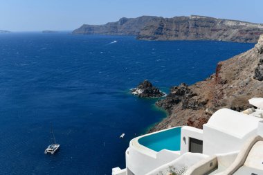 Yunanistan 'ın Santorini adasındaki Oia köyünün büyüleyici manzarası. Ege Denizi 'ndeki Caldera üzerinde geleneksel mavi kubbe kilisesi. Geleneksel mavi ve beyaz Cyclades mimarisi.